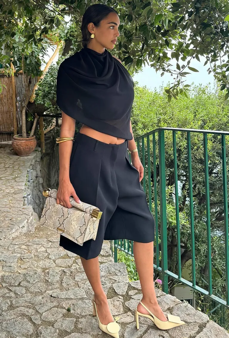 Yellow Slingback Heels Black Pleated Shorts Matching Draped Top Bag Gold Bangles Earrings